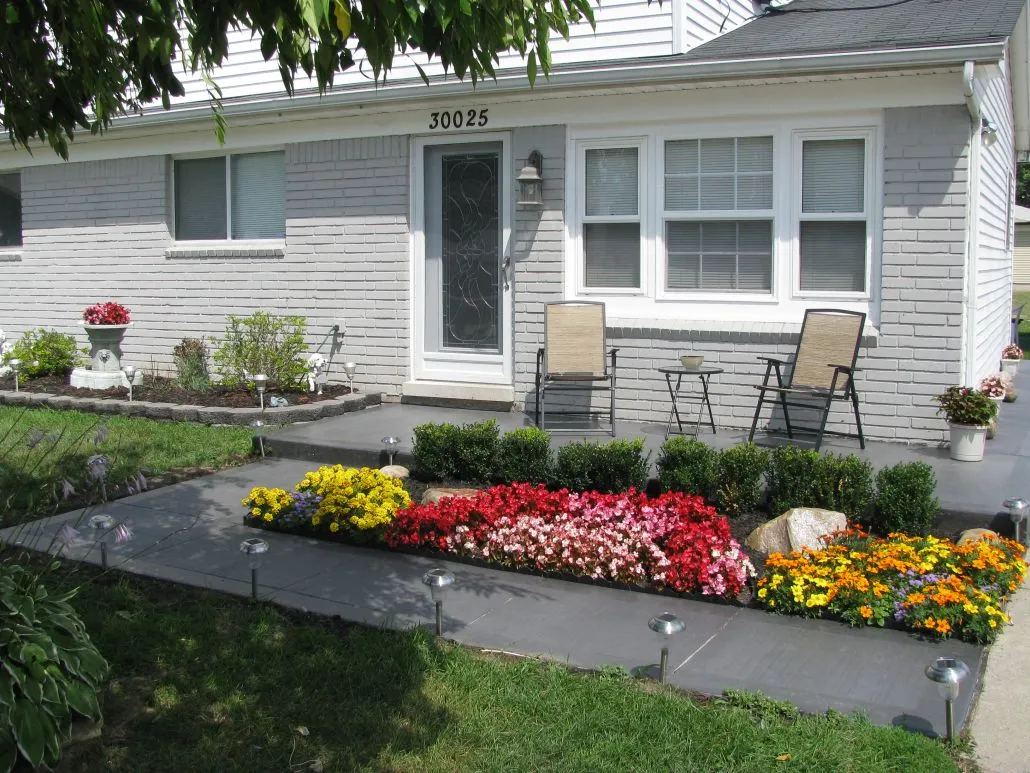 Charming residential home with flower bed and patio.