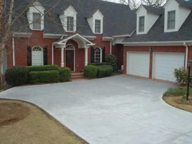 Elegant brick house with manicured lawn and driveway