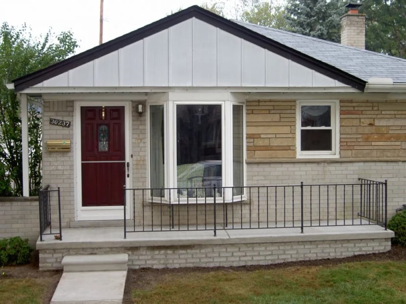 Brick house with red door and porch railing