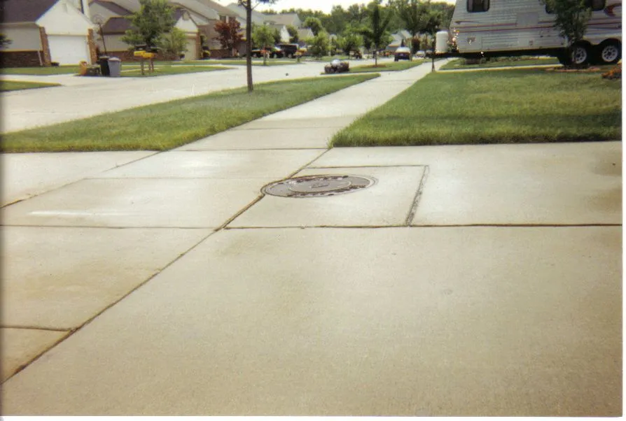 Residential street with concrete sidewalk and manhole cover